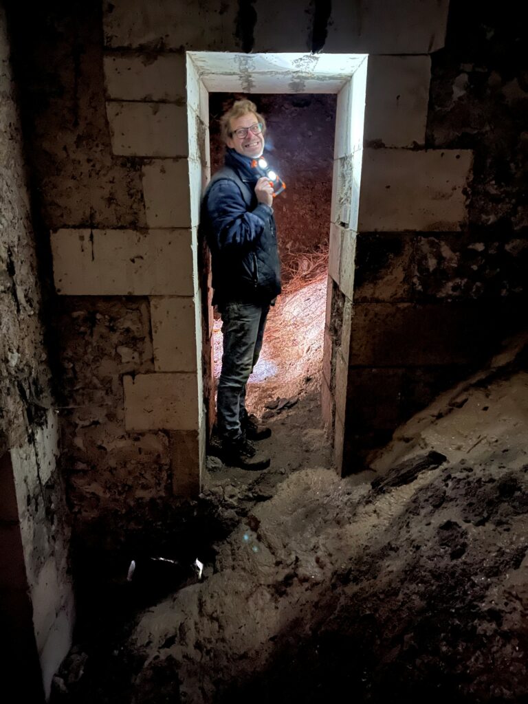 FOTO: Gérard er klar til besøg under kælderens fundament – Karen poserer foran nedgangen til den hvælvede kælder